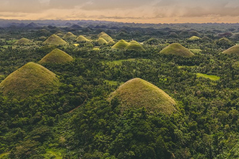 Scenic view of the Chocolate Hills in Bohol, Philippines, surrounded by lush greenery.