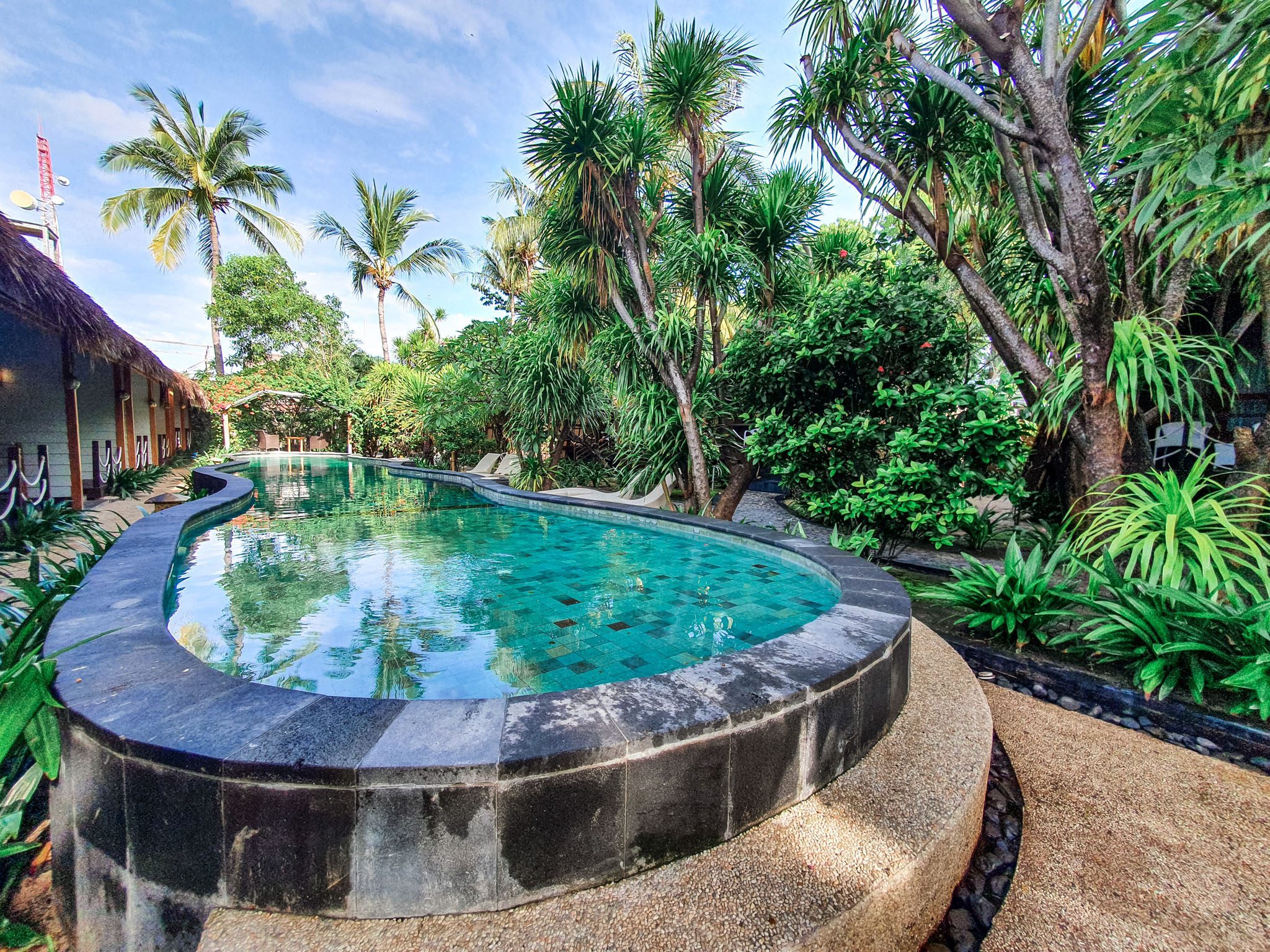 Tropical pool surrounded by lush greenery in the Gili Islands.