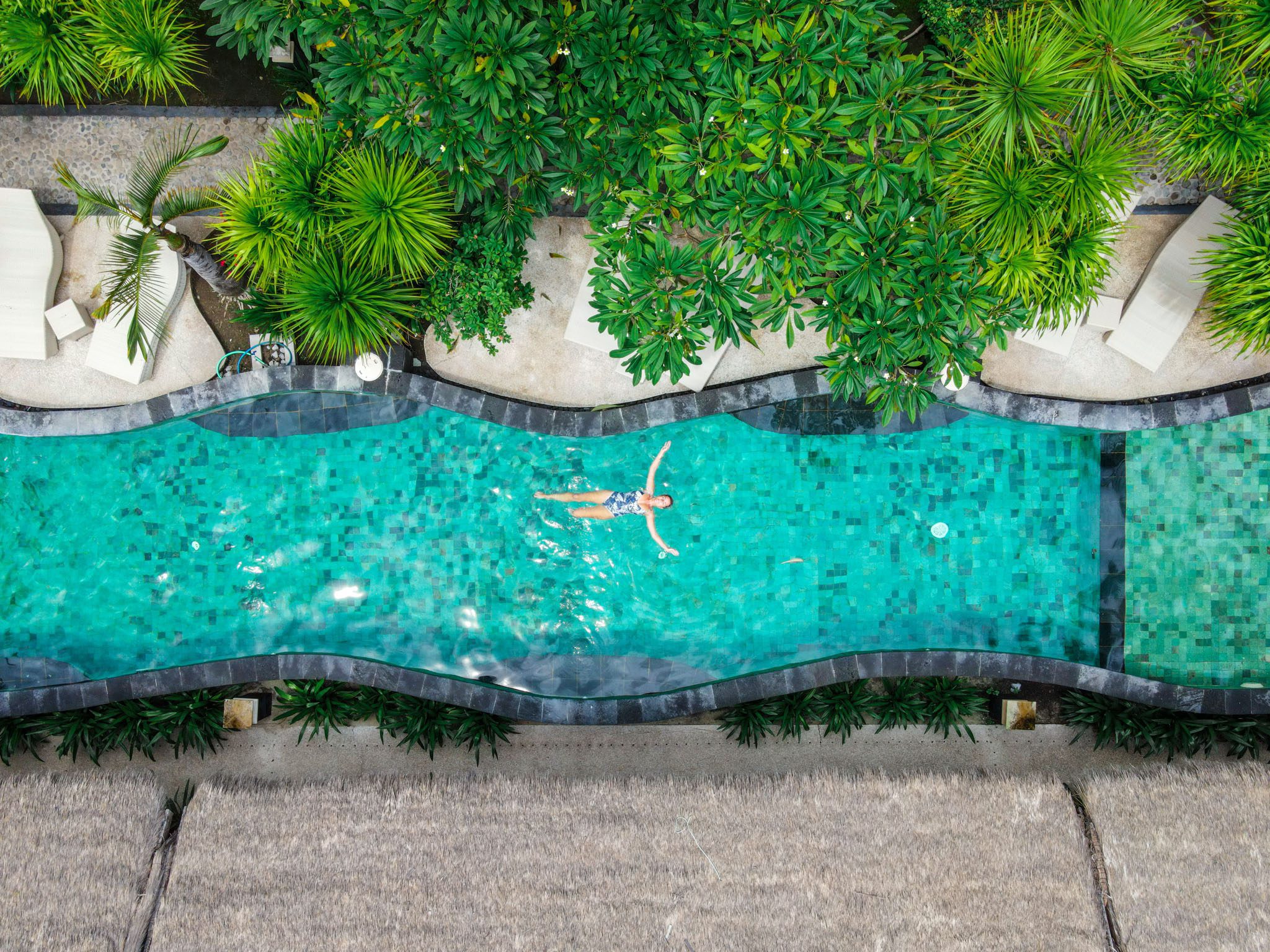 Aerial view of a turquoise pool surrounded by greenery in the Gili Islands.