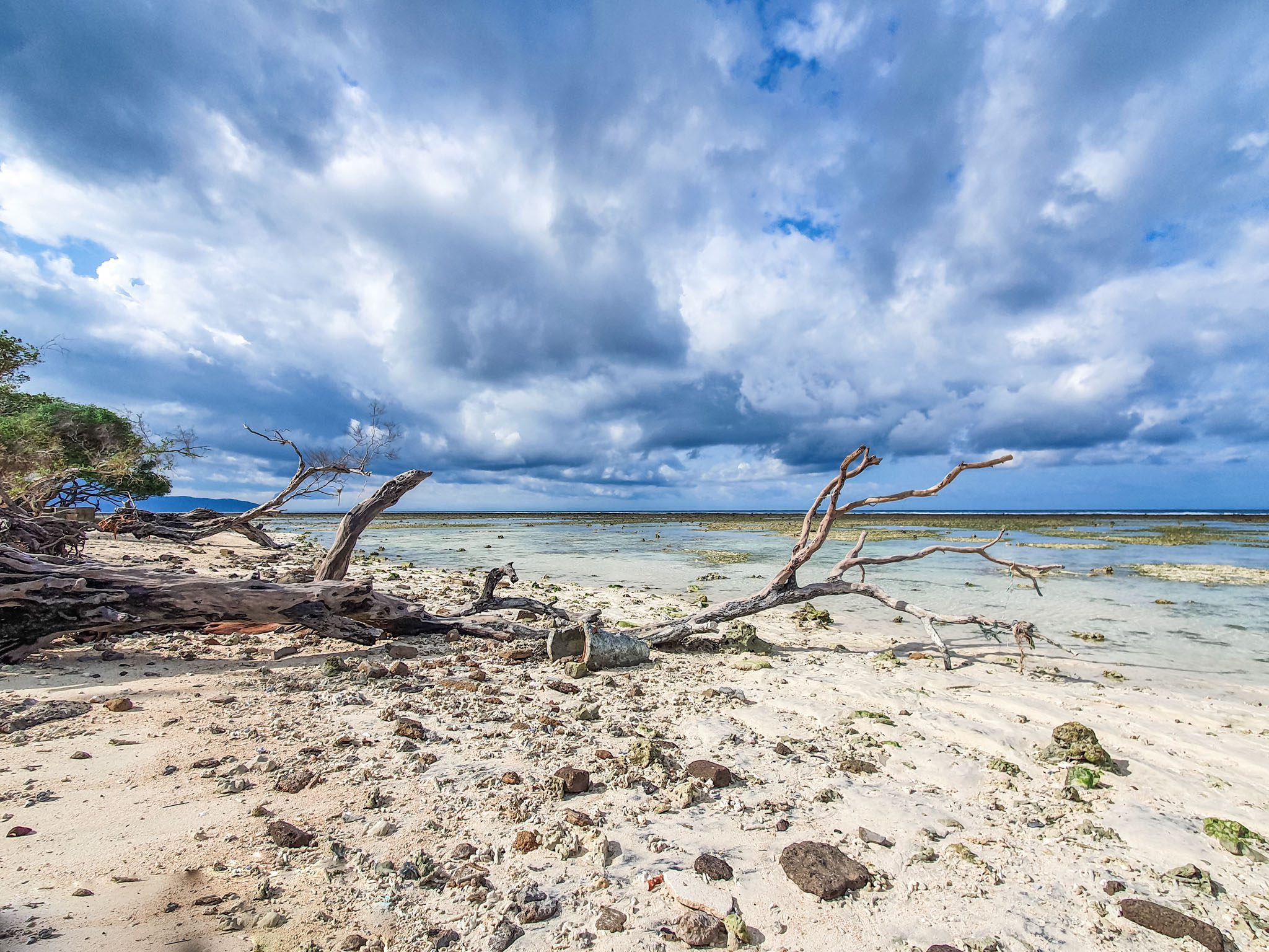 Dramatic skies over a rocky beach in the Gili Islands.
