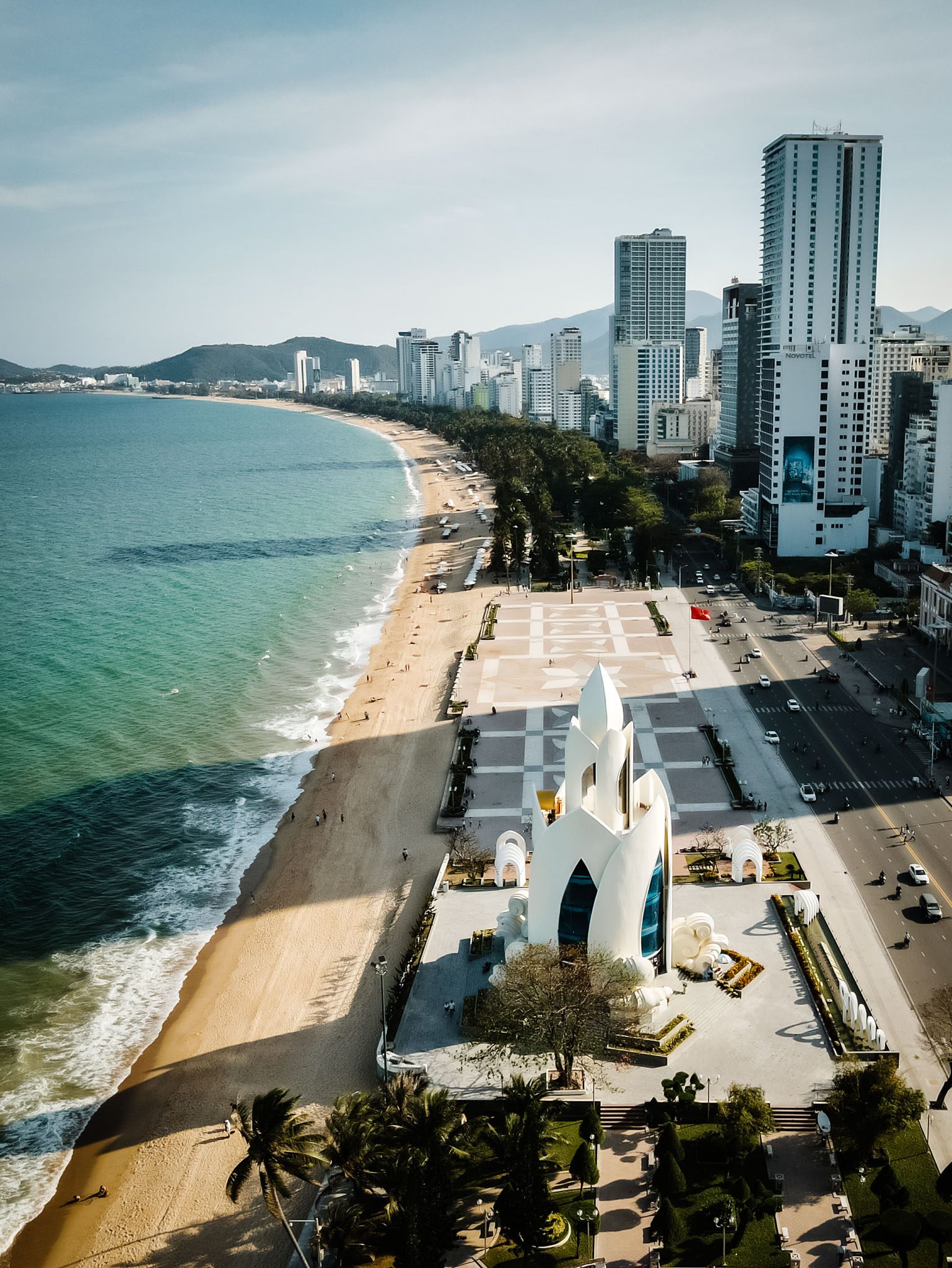 Aerial view of Nha Trang beach with the iconic Lotus Tower and high-rise buildings.